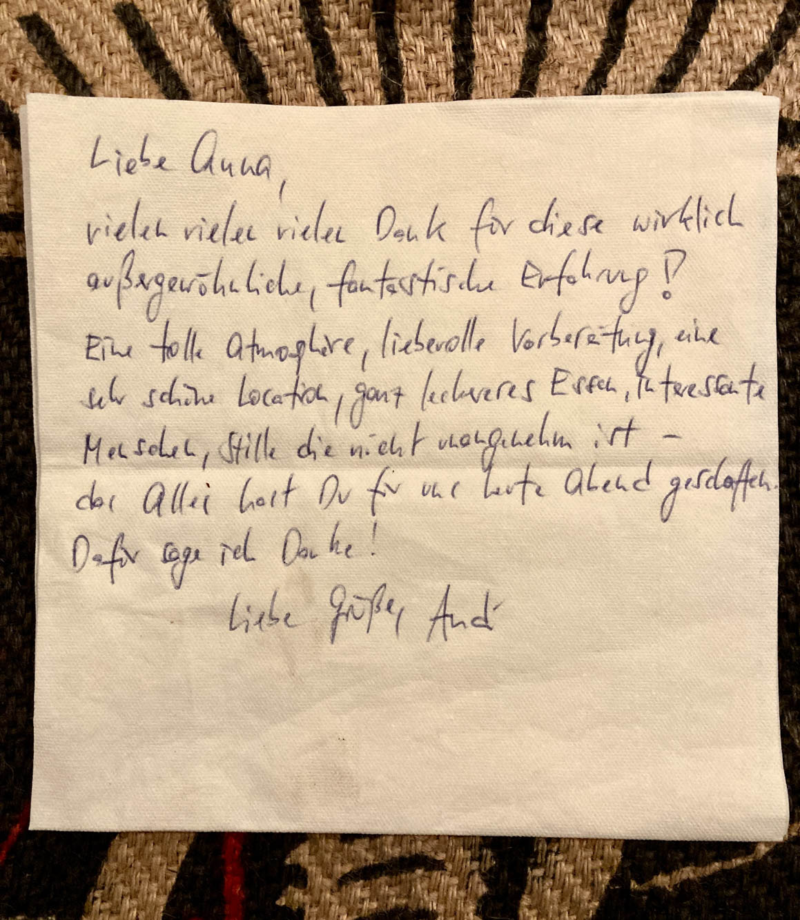 Auf einer Serviette steht handgeschrieben der folgende Text: „Vielen, vielen, vielen Dank für diese wirklich außergewöhnliche, fantastische Erfahrung! Eine tolle Atmosphäre, liebevolle Vorbereitung, eine sehr schöne Location, ganz leckereres Essen, interessante Menschen, Stille, die nicht unangenehm ist, – das alles hast Du für uns heute Abend geschaffen. Dafür sage ich Danke!“