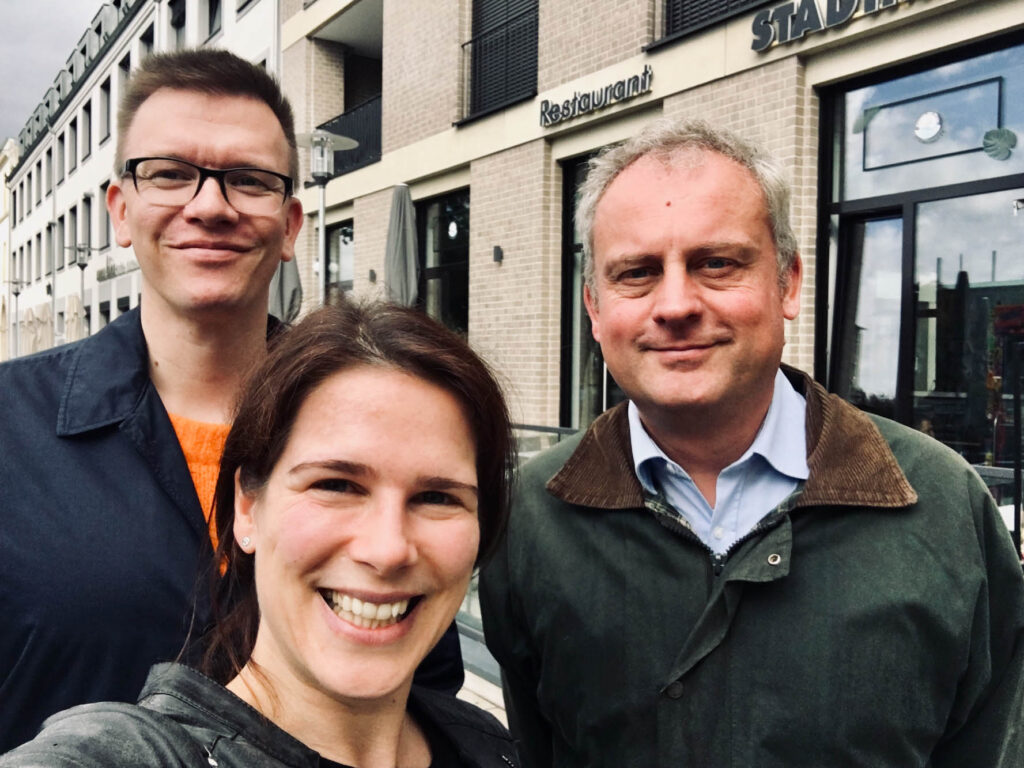 Eine Selfie-Aufnahme von Anna Brandes und zwei Lunch-Connection-Teilnehmern, draußen vor dem Restaurant.