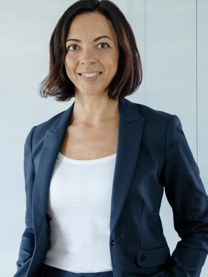 Anna Beissner Profilbild von Anna Beißner. Sie trägt ein weißes T-Shirt und einen dunkelblauen Blazer und blickt offen in die Kamera.