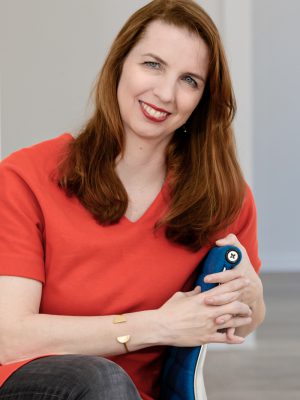 Kathrin Albrecht Profilbild von Kathrin Albrecht. Sie trägt ein rotes Oberteil, die Haare offen und blickt mit einem offenen Lächeln in die Kamera.